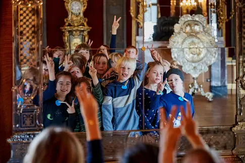 Kinder posieren vor einem Spiegel und ziehen Grimassen